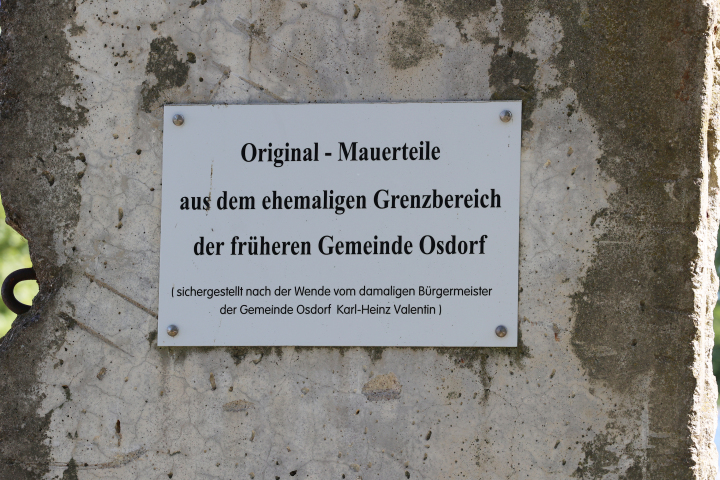 Nahaufnahme einer Gedenktafel an einem der Mauerteile aus dem Grenzbereich der früheren Gemeinde Osdorf