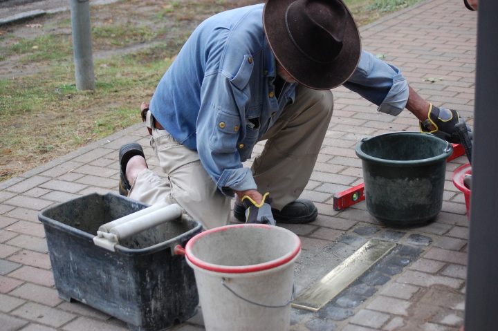 Der Künstler Gunter Demnig verlegt die Stolperschwelle vor dem Sally-Bein-Gymnasium in Beelitz.